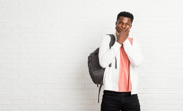 Giovane bocca della copertura dello studente afroamericano dell&#39;uomo con entrambe le mani