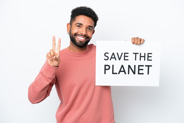 Giovane brasiliano isolato su sfondo bianco con in mano un cartello con testo Save the Planet e celebrando una vittoria