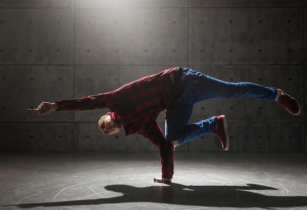 Giovane breakdancer maschio alla moda che posa nello studio