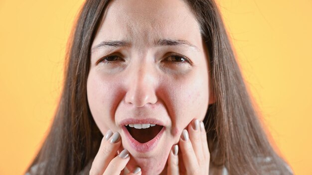 Giovane bruna con mal di denti Closeup ritratto di sconvolto sconvolto confuso giovane donna Foto di alta qualità