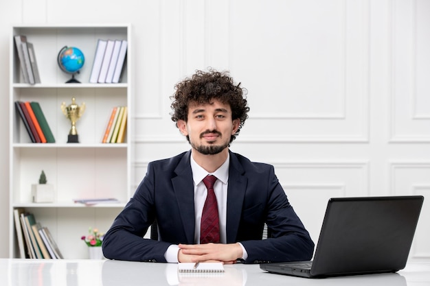 Giovane bruna riccio di servizio clienti in vestito dell'ufficio con il computer portatile