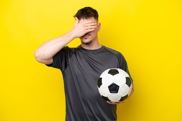 Giovane calciatore uomo isolato su sfondo giallo che copre gli occhi con le mani Non voglio vedere qualcosa