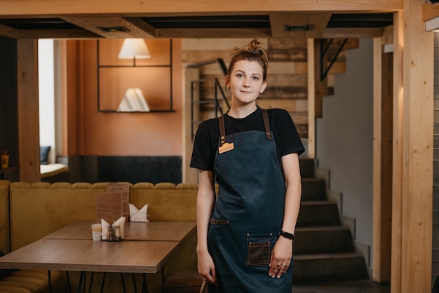 Giovane cameriera di bar che posa in un ristorante