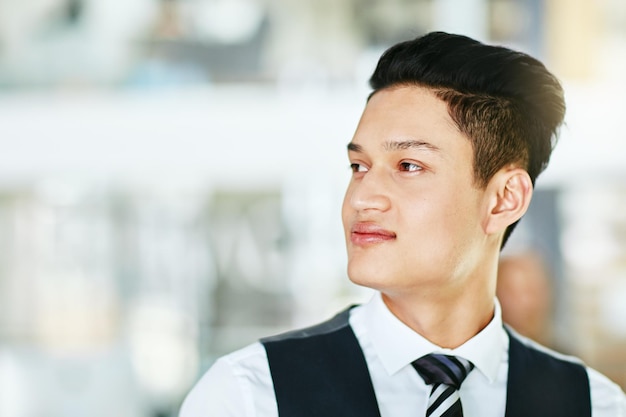 Giovane cameriere professionista barista o host che sembra sicuro di sé e indossa un'uniforme formale su uno sfondo sfocato Profilo laterale primo piano testa e volto di un uomo che lavora nell'ospitalità