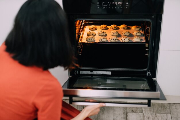 Giovane casalinga che produce biscotti fatti in casa in cucina