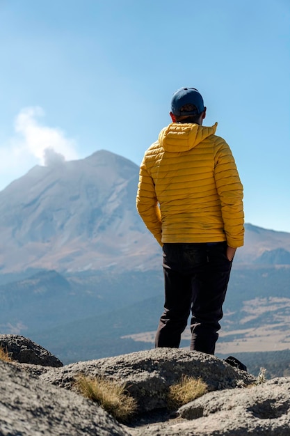 Giovane che cammina sulla montagna iztaccihuatl all'alba sullo sfondo il vulcano popocatepetl