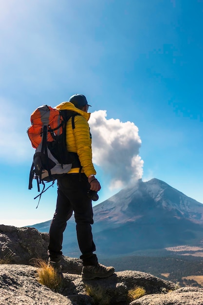 Giovane che cammina sulla montagna iztaccihuatl all'alba sullo sfondo il vulcano popocatepetl