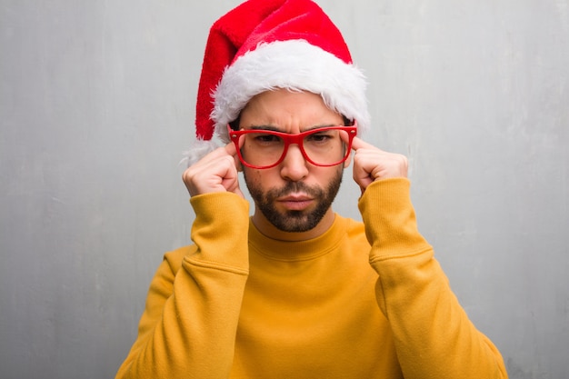 Giovane che celebra i regali della tenuta del giorno di Natale che fanno un gesto di concentrazione