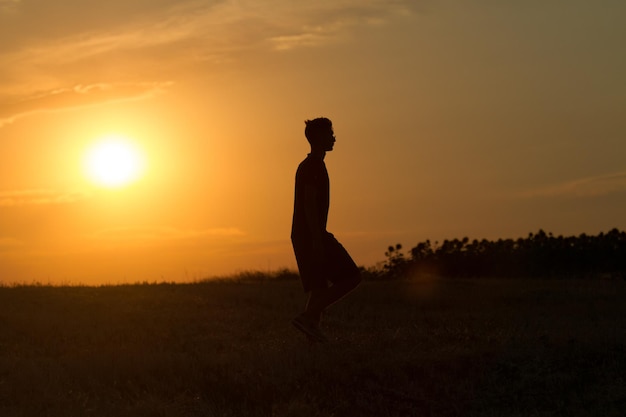 giovane che corre e mostra movimento al tramonto