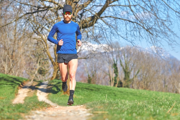 Giovane che corre su un prato di montagna