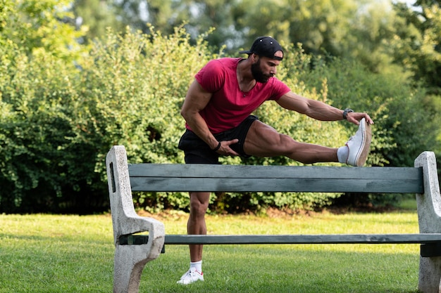 Giovane che esercita stretching nel parco urbano