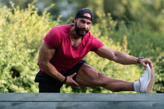 Giovane che esercita stretching nel parco urbano