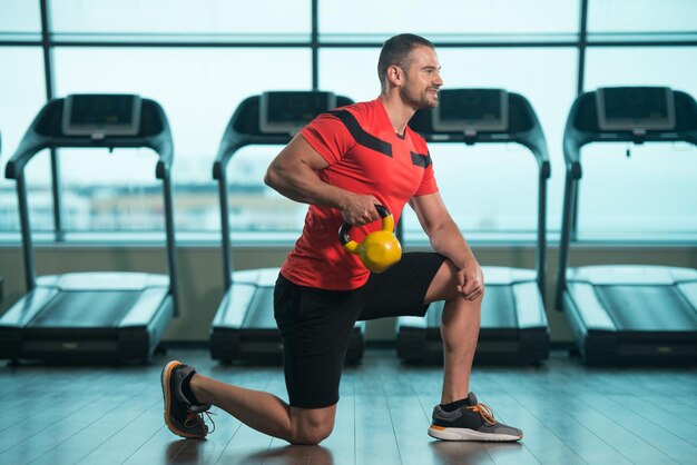 Giovane che fa esercizio con il bollitore in palestra