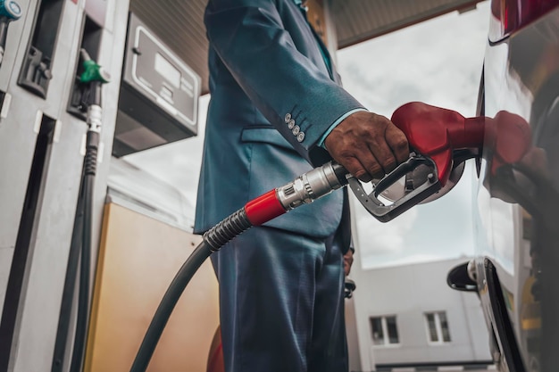 Giovane che fa rifornimento di carburante alla sua auto moderna alla stazione di servizio