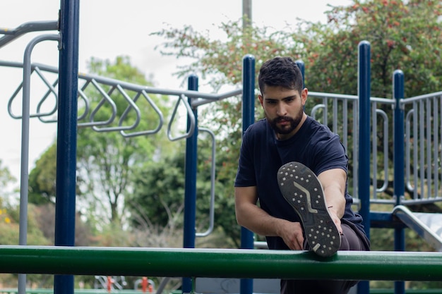 giovane che fa stretching durante il suo allenamento in un parco della città