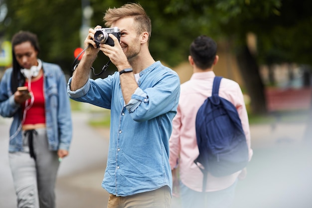 Giovane che fotografa sulla vecchia macchina fotografica