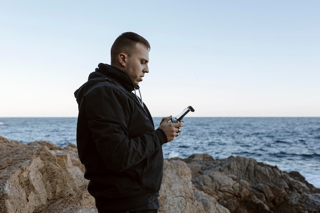 Giovane che gestisce un drone sul mare Foto di alta qualità