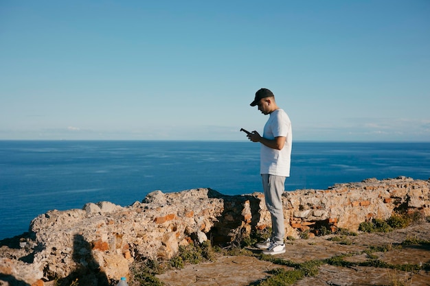 Giovane che gestisce un drone sul mare Foto di alta qualità