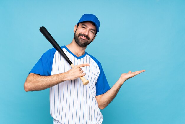 Giovane che gioca a baseball sopra il copyspace blu isolato della tenuta immaginario sulla palma per inserire un annuncio