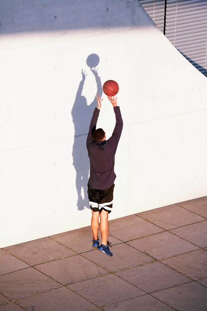 Giovane che gioca a basket in città