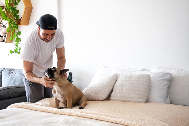 Giovane che gioca con il suo cane su un letto