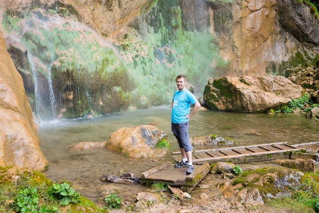 Giovane che gode nel parco naturale alla base della grande cascata