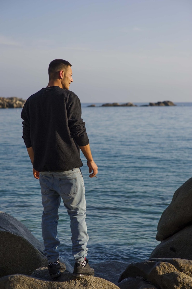 Foto giovane che guarda il mare contro il cielo