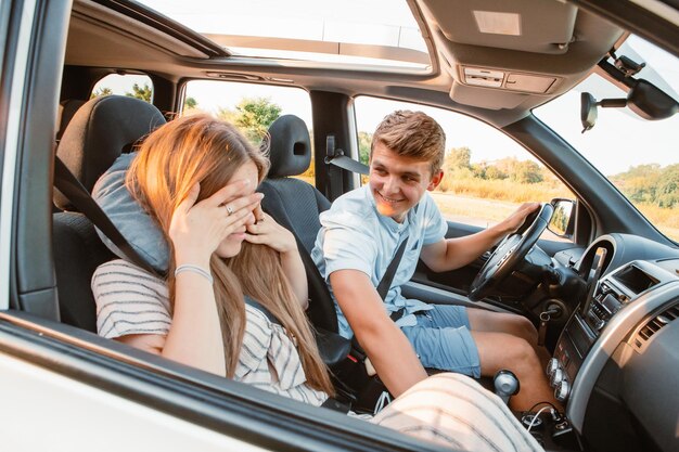 Giovane che guida la donna dell'automobile che dorme con il cuscino