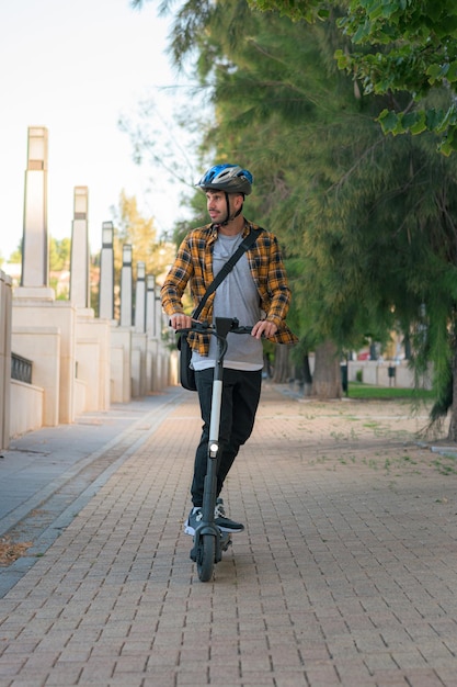 Giovane che guida uno scooter elettrico attraverso un parco