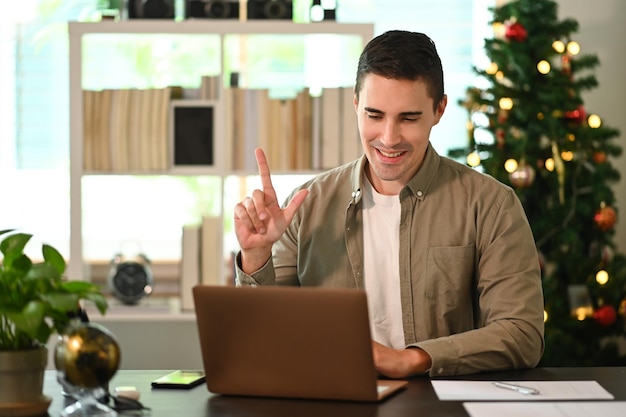 Giovane che ha una videoconferenza con un computer portatile a casa