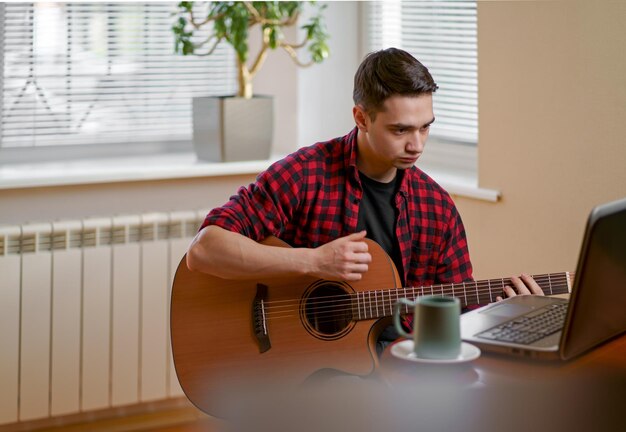 Giovane che impara a suonare la chitarra online