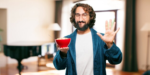 Giovane che indossa abito da notte accappatoio con una ciotola per la colazione