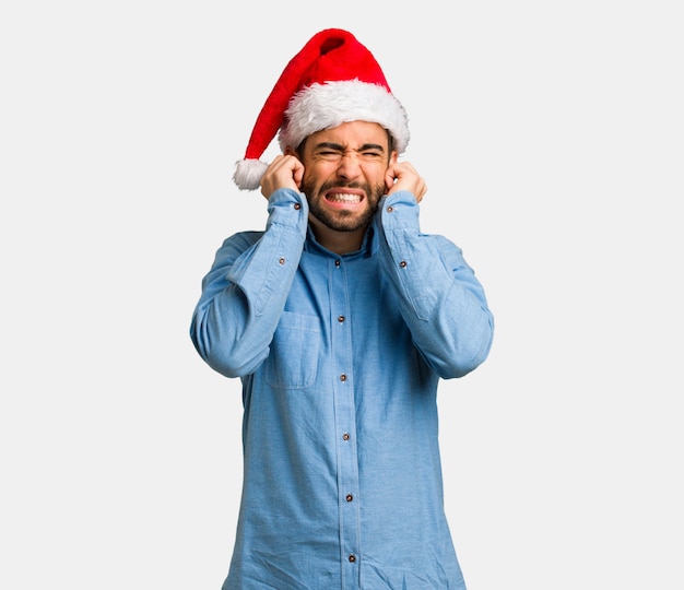 Giovane che indossa le orecchie della copertura del cappello di Santa con le mani