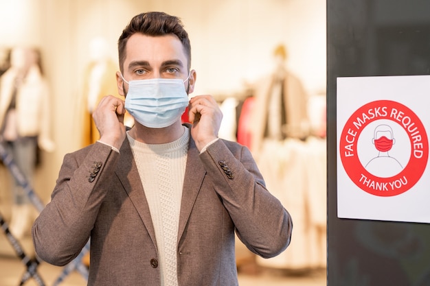 Giovane che indossa una maschera durante lo shopping