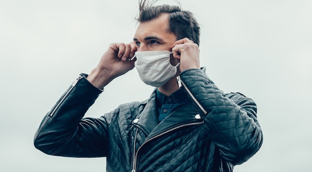 Giovane che indossa una maschera protettiva in piedi sulla strada. foto con copia-spazio