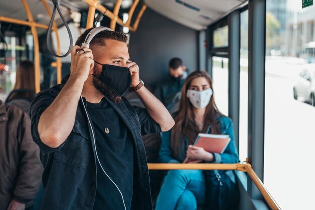 Giovane che indossa una maschera protettiva mentre guida un autobus