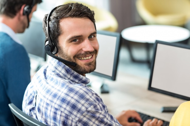 Giovane che lavora al computer con l'auricolare