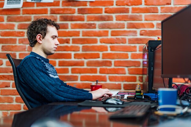 Giovane che lavora al computer in ufficio a casa