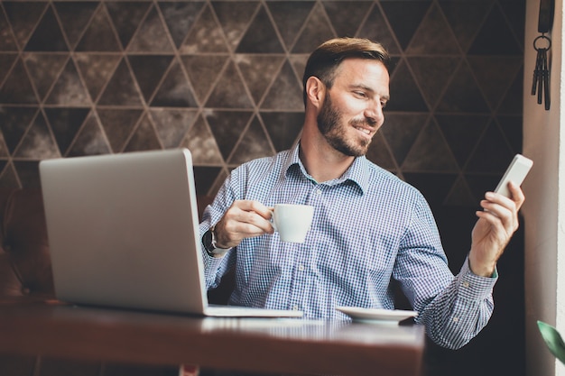 Giovane che lavora al computer portatile nel caffè