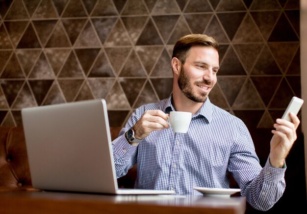 Giovane che lavora al computer portatile nel caffè