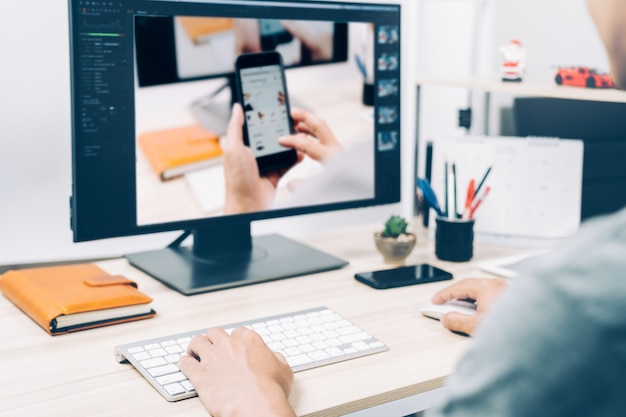 Giovane che lavora gli stili della foto di modifica sullo schermo di computer del pc a casa, affare di fotografia