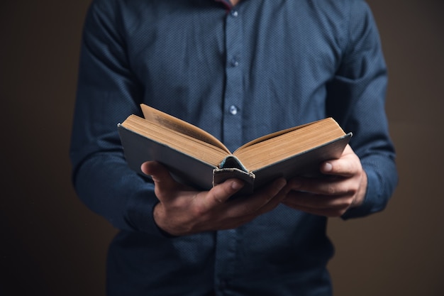 Giovane che legge un libro su una superficie marrone