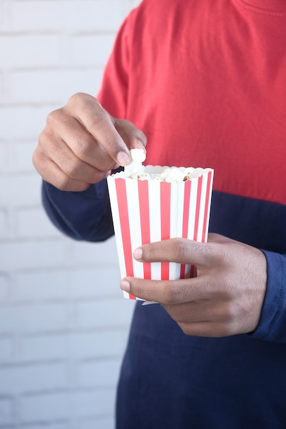 Giovane che mangia popcorn da vicino.