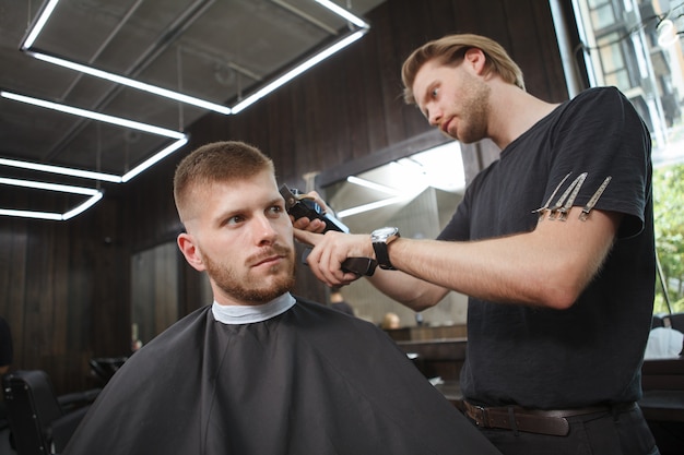 Giovane che ottiene nuovo taglio di capelli al negozio di barbiere