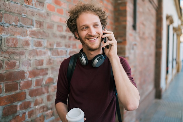 Giovane che parla al telefono all'aperto.