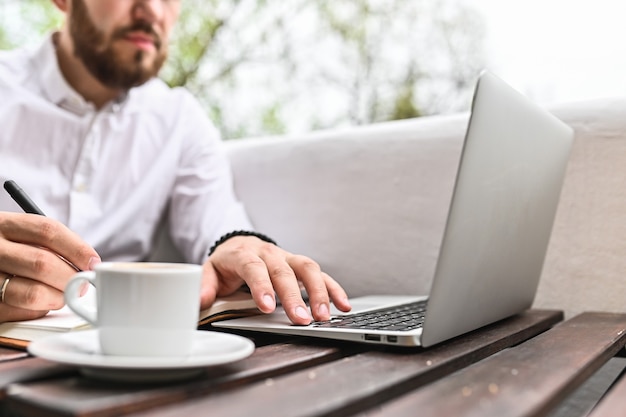 Giovane che per mezzo del computer portatile a casa primo piano delle mani dell'uomo che digita sulla tecnologia di istruzione di lifestyle dello studente freelance dell'interno del computer e concetto di acquisto in linea