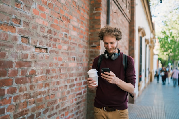 Giovane che per mezzo del suo telefono cellulare.