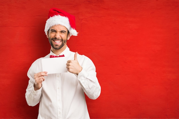 Giovane che porta un cappello del Babbo Natale il giorno di Natale