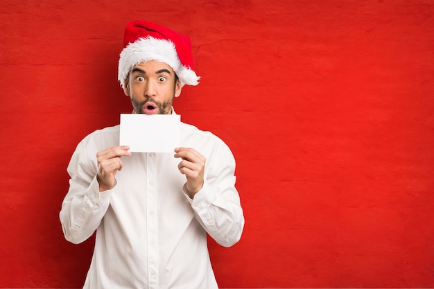 Giovane che porta un cappello del Babbo Natale il giorno di Natale