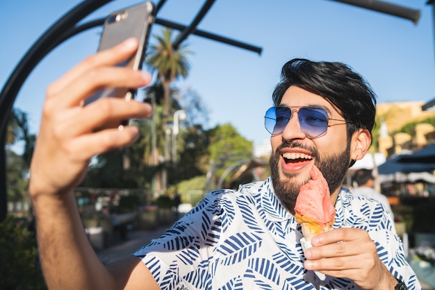 Giovane che prende selfie mentre mangiando il gelato